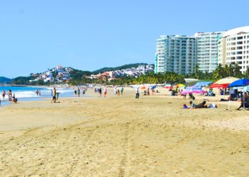Combaten turistas sol y altas temperaturas refrescándose en Playa El Palmar de Ixtapa